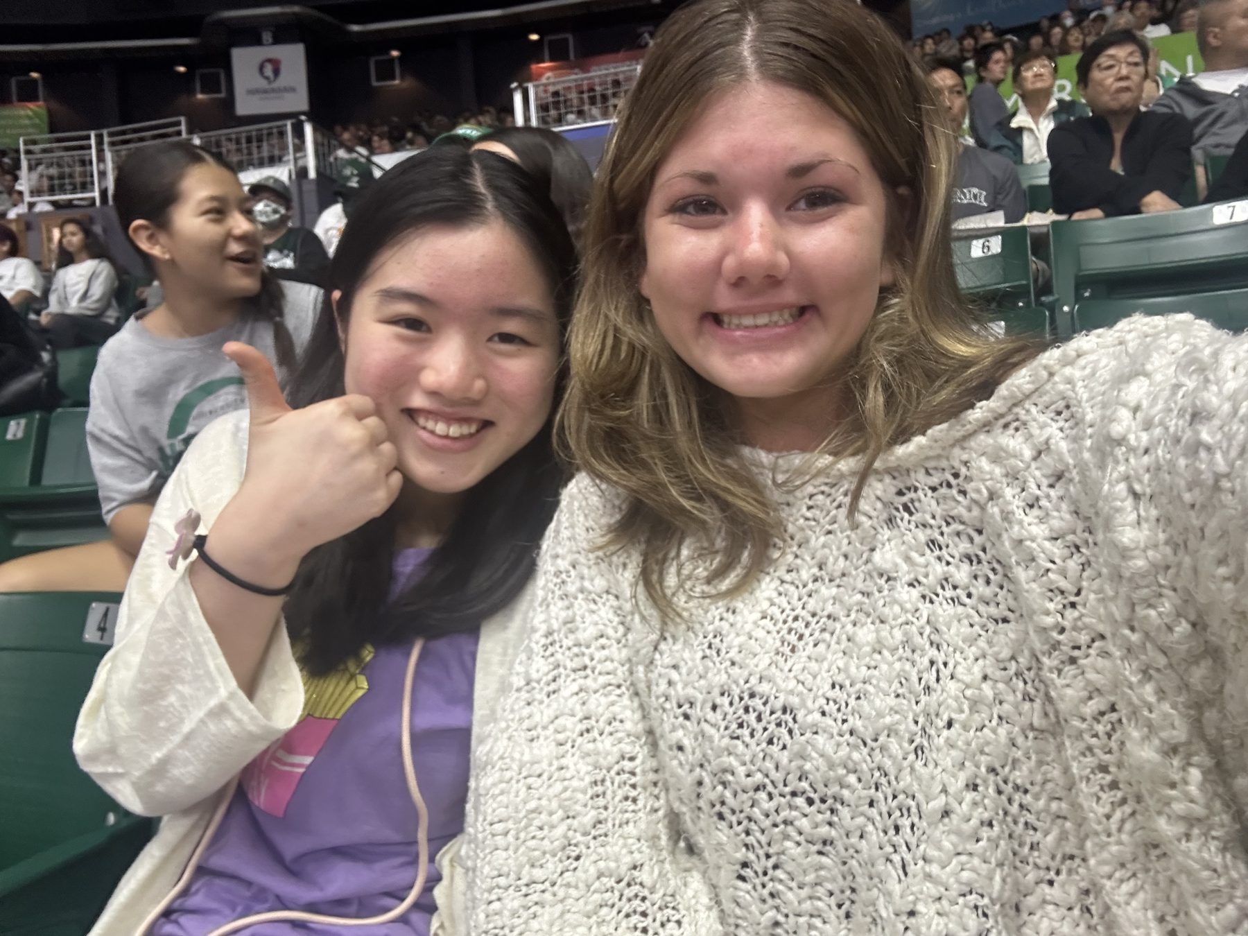 Stella with a friend in stadium seating in Japan