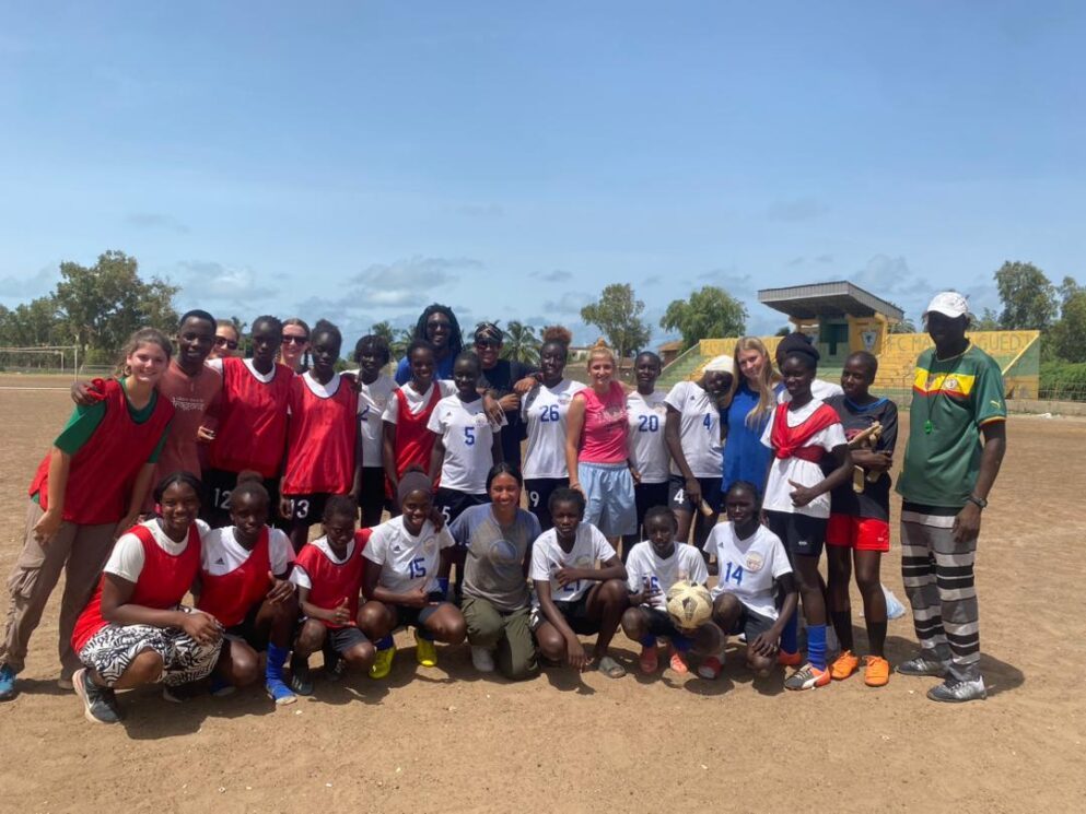 Girls soccer team group photo on a dirt field in Senegal