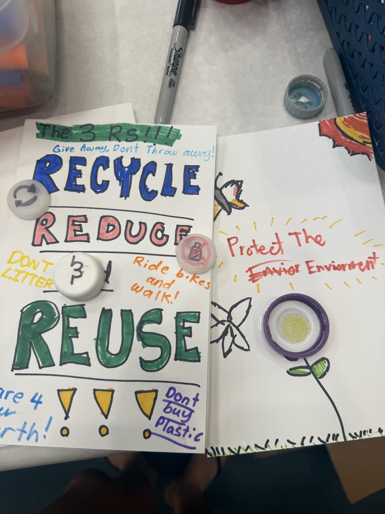 Student-made recycle, reduce, reuse posters using bottle caps